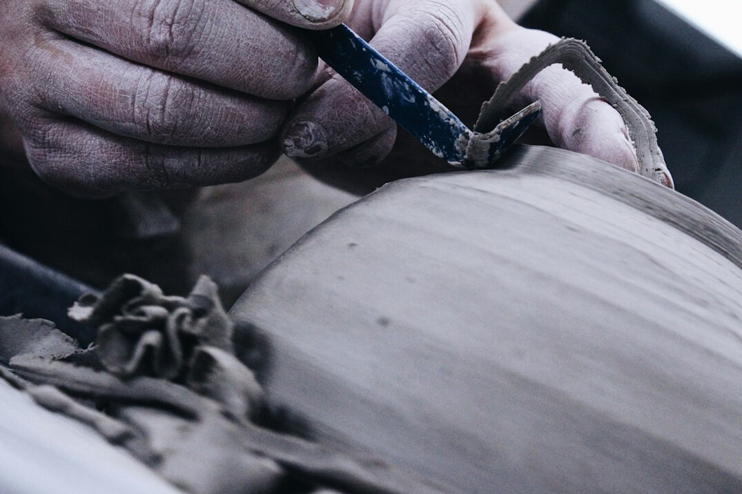 Hands working on a car body part with tools