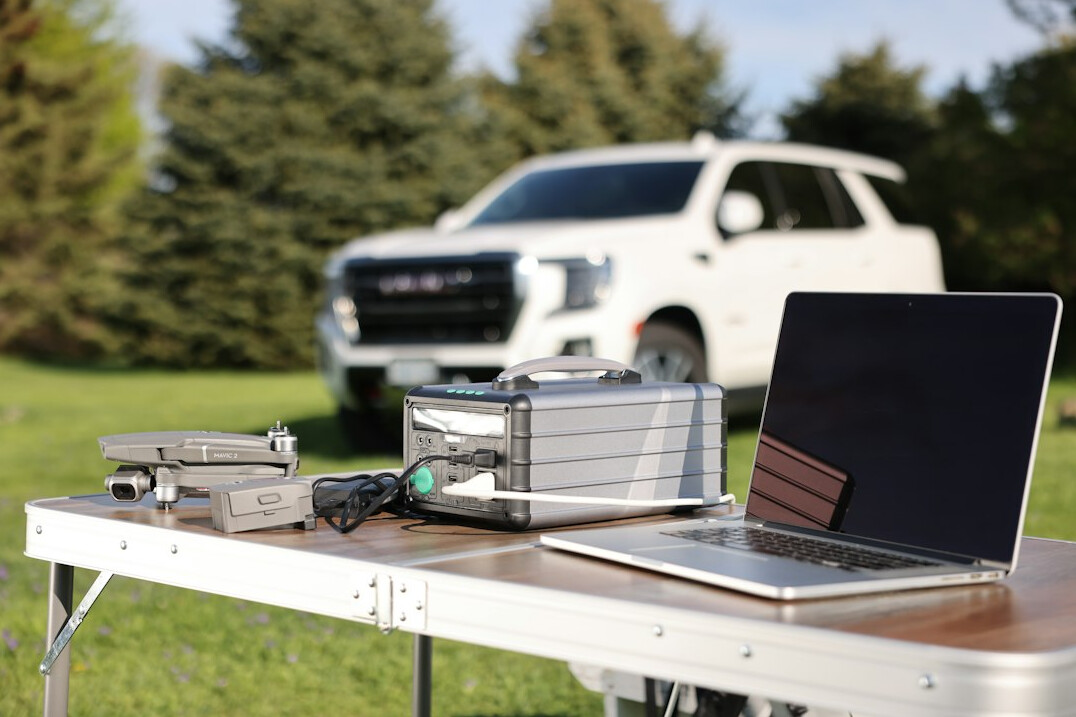 Laptop and tools next to a car for a video repair session